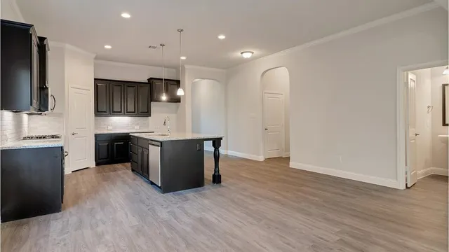 a kitchen with granite countertop a sink stove and cabinets