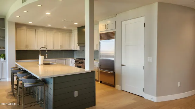 a kitchen with kitchen island a sink appliances and cabinets