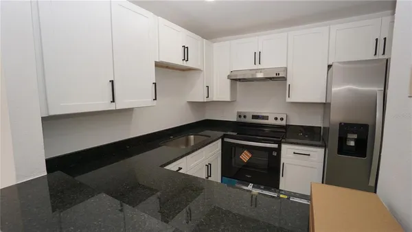 a kitchen with stainless steel appliances granite countertop a stove a refrigerator and a sink