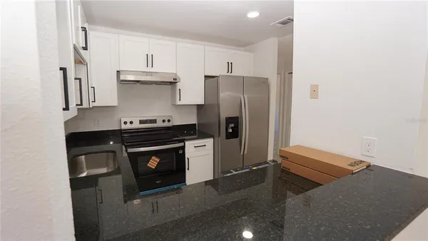 a kitchen with stainless steel appliances a refrigerator stove and cabinets