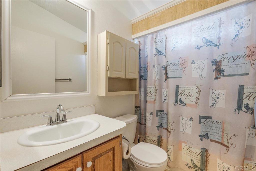 13941 Wisteria Avenue, Unit 53 Poway, CA 92064 - Photo 13 of 28 a bathroom with a sink toilet a mirror and shower
