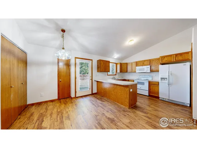 a kitchen with stainless steel appliances kitchen island granite countertop a refrigerator and a sink