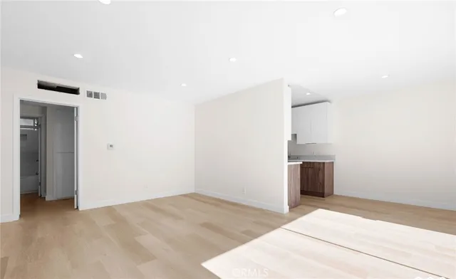 a view of empty room with wooden floor and window