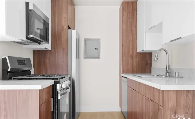 a kitchen with stainless steel appliances a sink stove refrigerator and cabinets