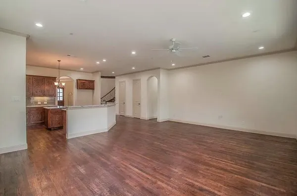 a view of kitchen with kitchen island a sink wooden floor and a refrigerator