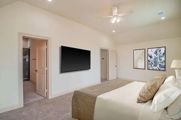 a bedroom with a large bed and a flat screen tv