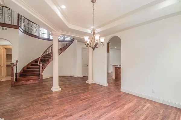 a view of a livingroom with wooden floor and staircase