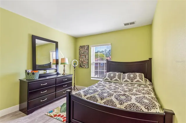 a bedroom with a bed and wooden floor