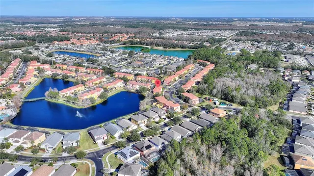 an aerial view of a house with swimming pool and lake view