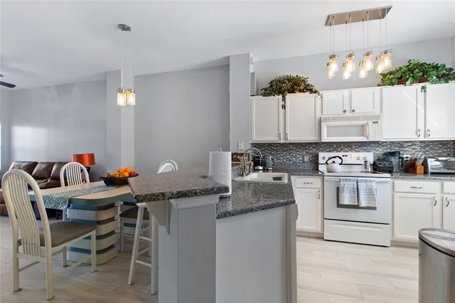 a kitchen with granite countertop a sink and cabinets