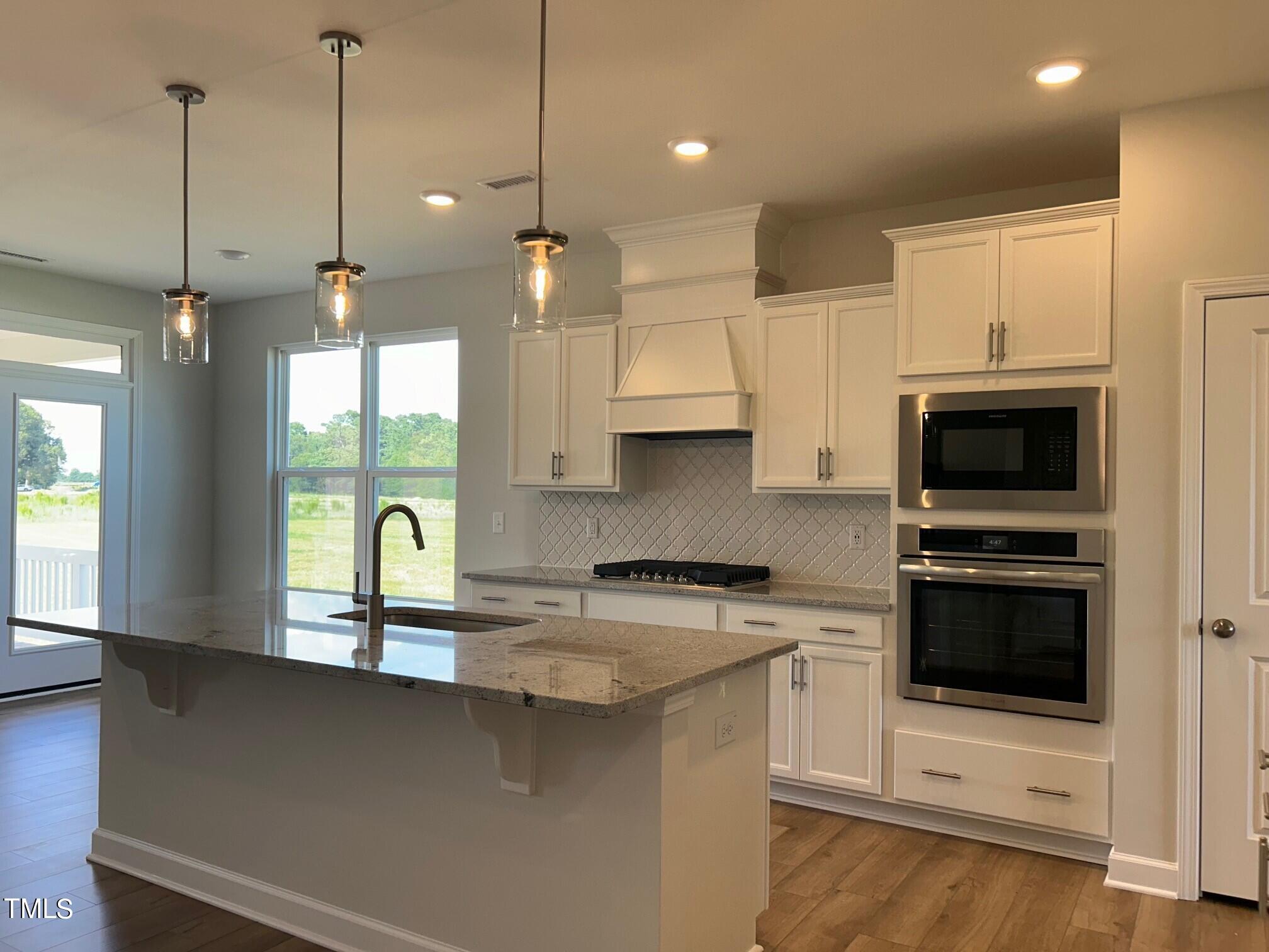34 Looping Court Angier, NC 27501 - Photo 4 of 25 a kitchen with stainless steel appliances granite countertop a sink a stove and a refrigerator