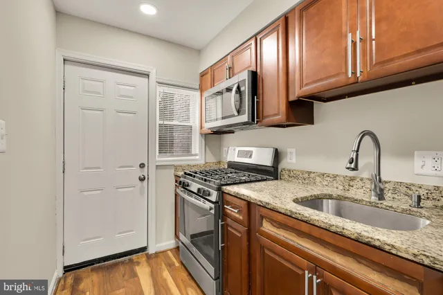 a kitchen with stainless steel appliances granite countertop a sink stove and cabinets