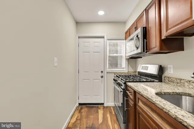 a kitchen with granite countertop a sink and a stove top oven