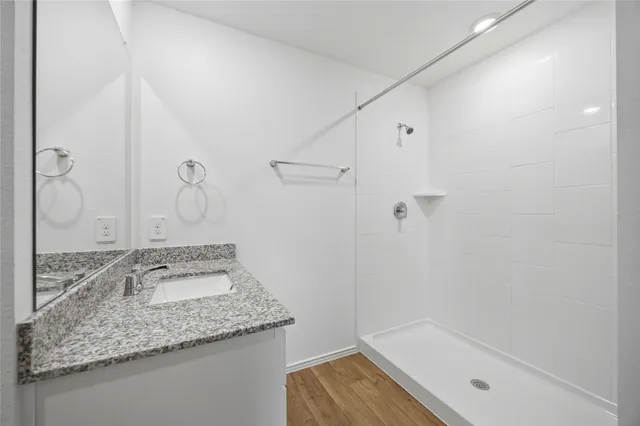 a bathroom with a granite countertop sink and a mirror
