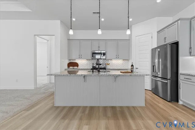 a kitchen with kitchen island a sink a refrigerator and a stove