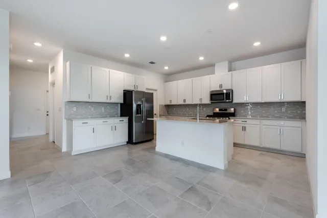 a kitchen with white cabinets and stainless steel appliances