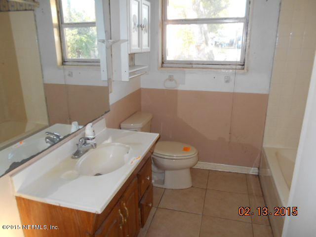 7057 Clovis Road Jacksonville, FL 32205 - Photo 7 of 12 a bathroom with a sink a toilet and a window