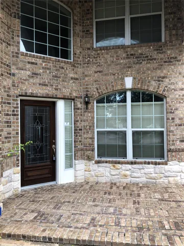 an empty room with wooden floor and windows in it