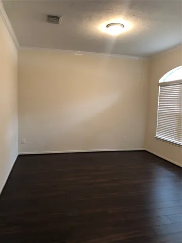 an empty room with wooden floor and a window