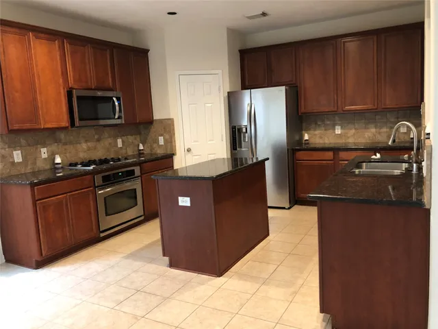 a kitchen with a stove a sink and a microwave