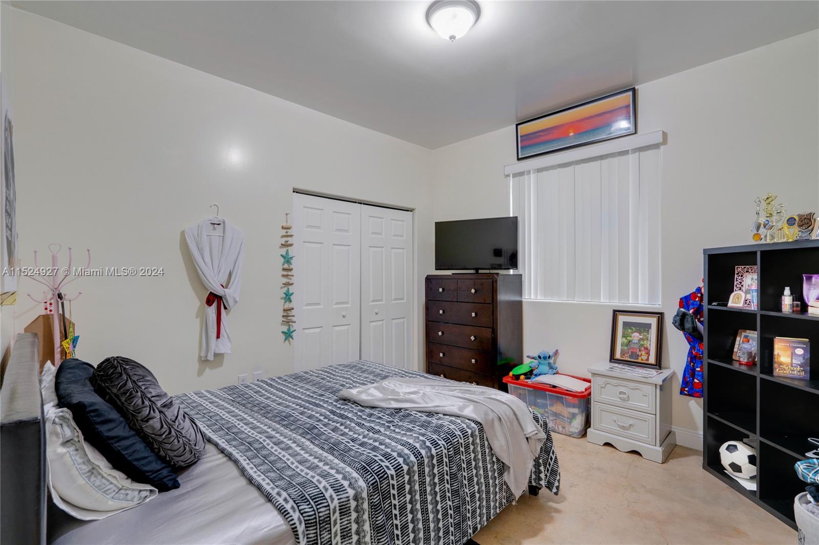 10129 West Jessamine Street Miami, FL 33157 - Photo 24 of 50 a bedroom with a bed and a book shelf