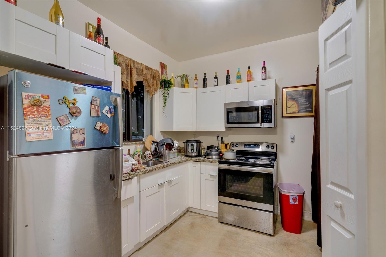 10129 West Jessamine Street Miami, FL 33157 - Photo 45 of 50 a kitchen with stainless steel appliances a refrigerator and a stove top oven
