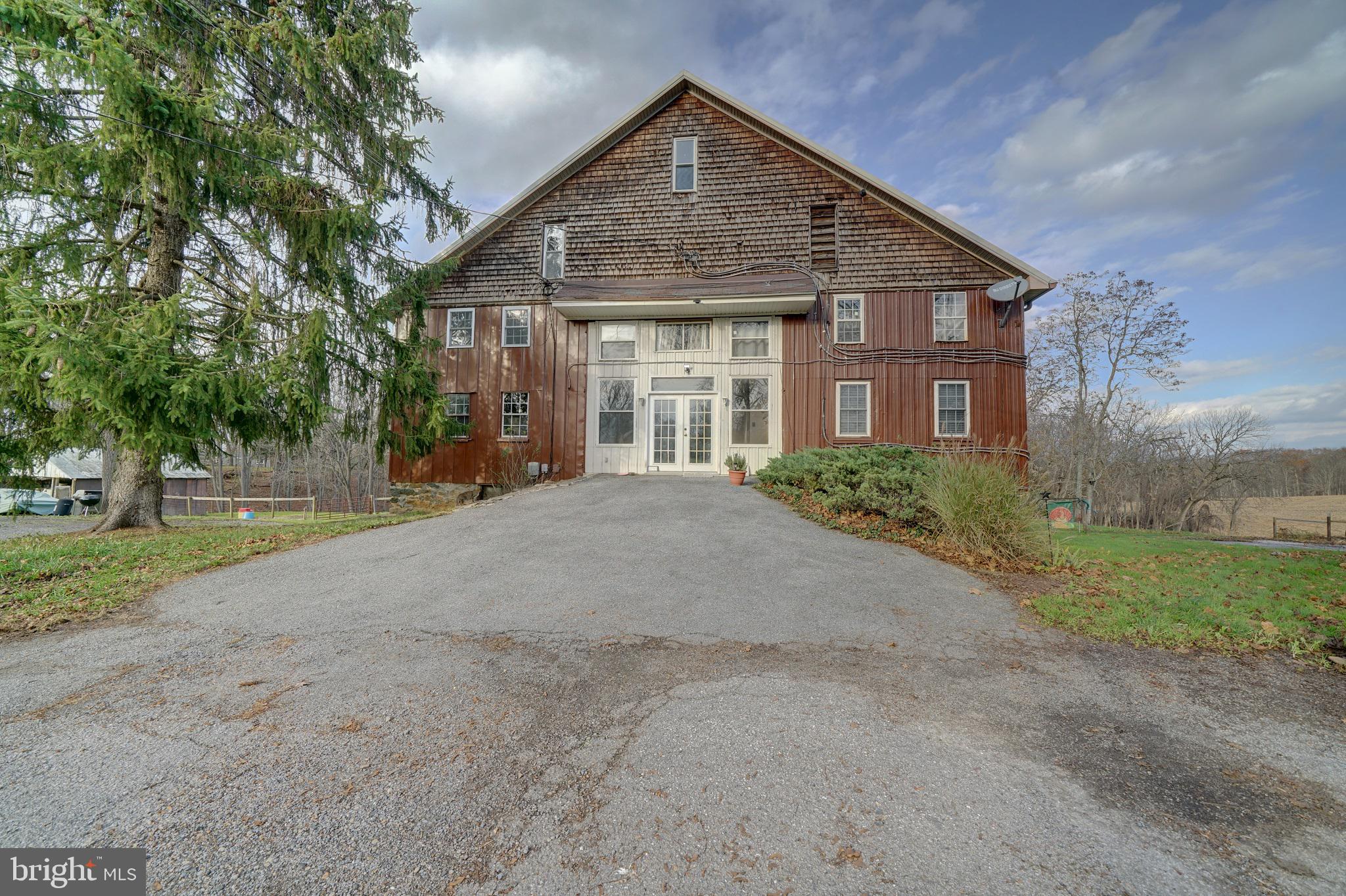 a view of a big house with a yard and large trees