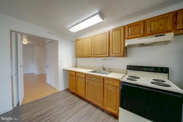 a kitchen with a sink cabinets and wooden floor