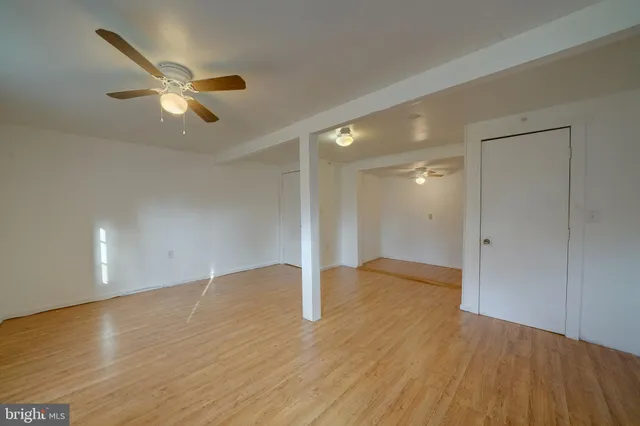 a view of empty room with wooden floor