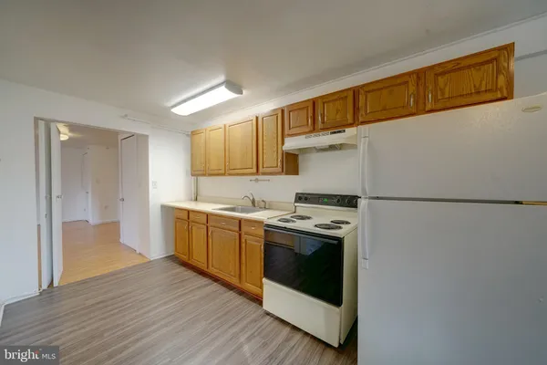 a kitchen with a white stove top oven and refrigerator