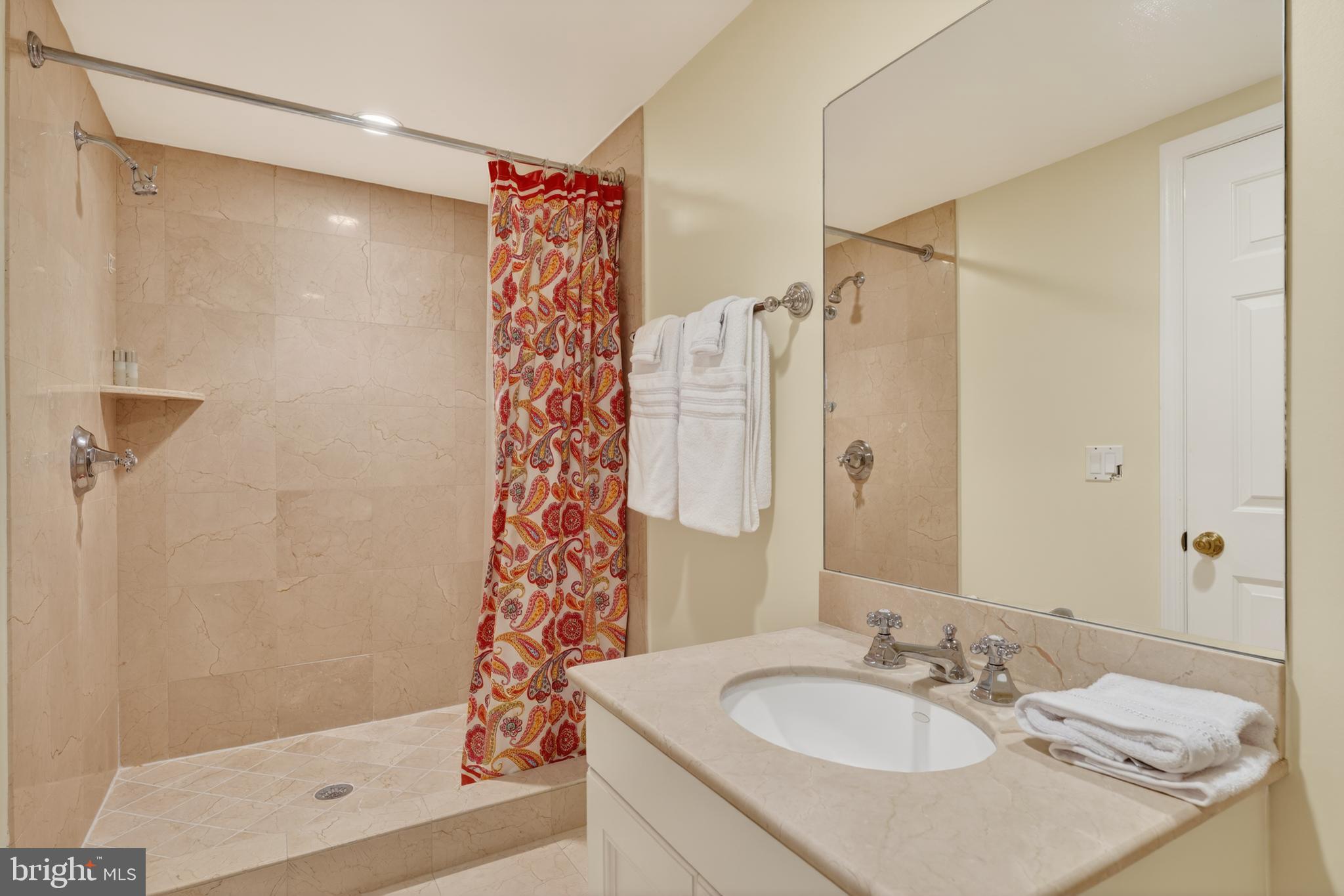 2238 47th Street Northwest Washington, DC 20007 - Photo 39 of 42 a bathroom with a granite countertop shower sink vanity and mirror