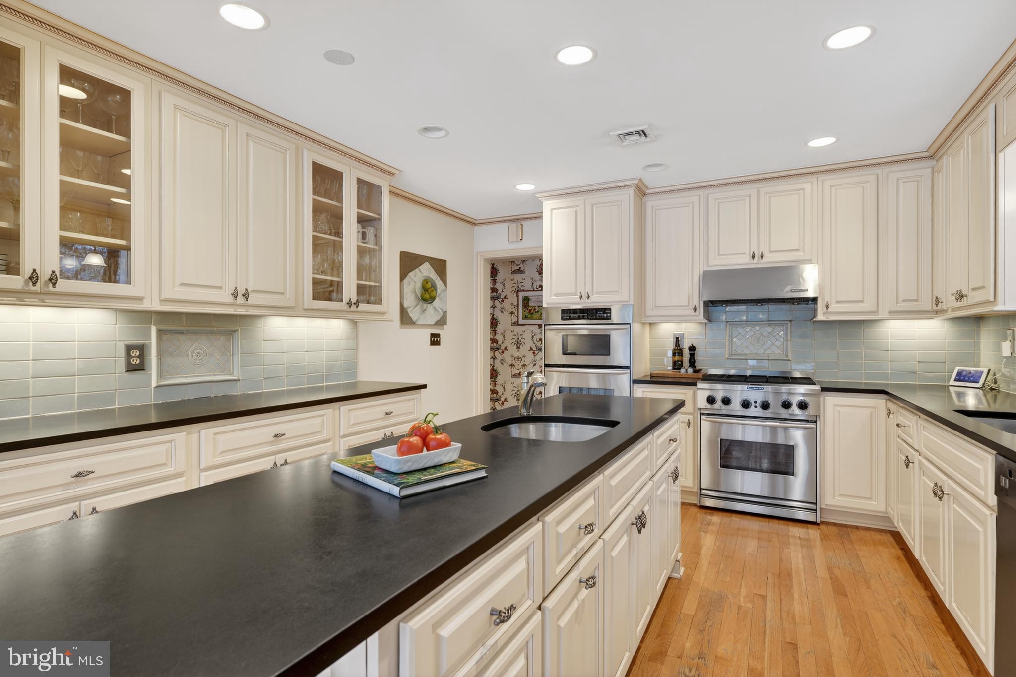 2238 47th Street Northwest Washington, DC 20007 - Photo 9 of 42 a kitchen with stainless steel appliances granite countertop a sink stove and cabinets