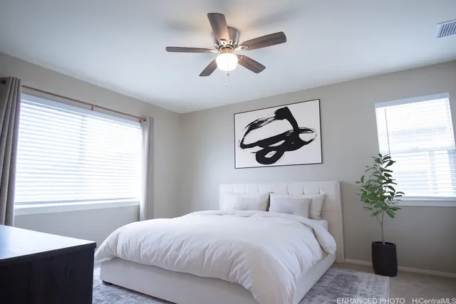 a bedroom with a large bed and a potted plant