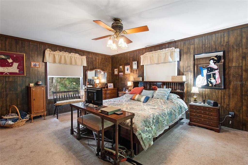 3641 Turtle Mound Road Melbourne, FL 32934 - Photo 28 of 77 a bedroom with a bed table chair and flat screen tv