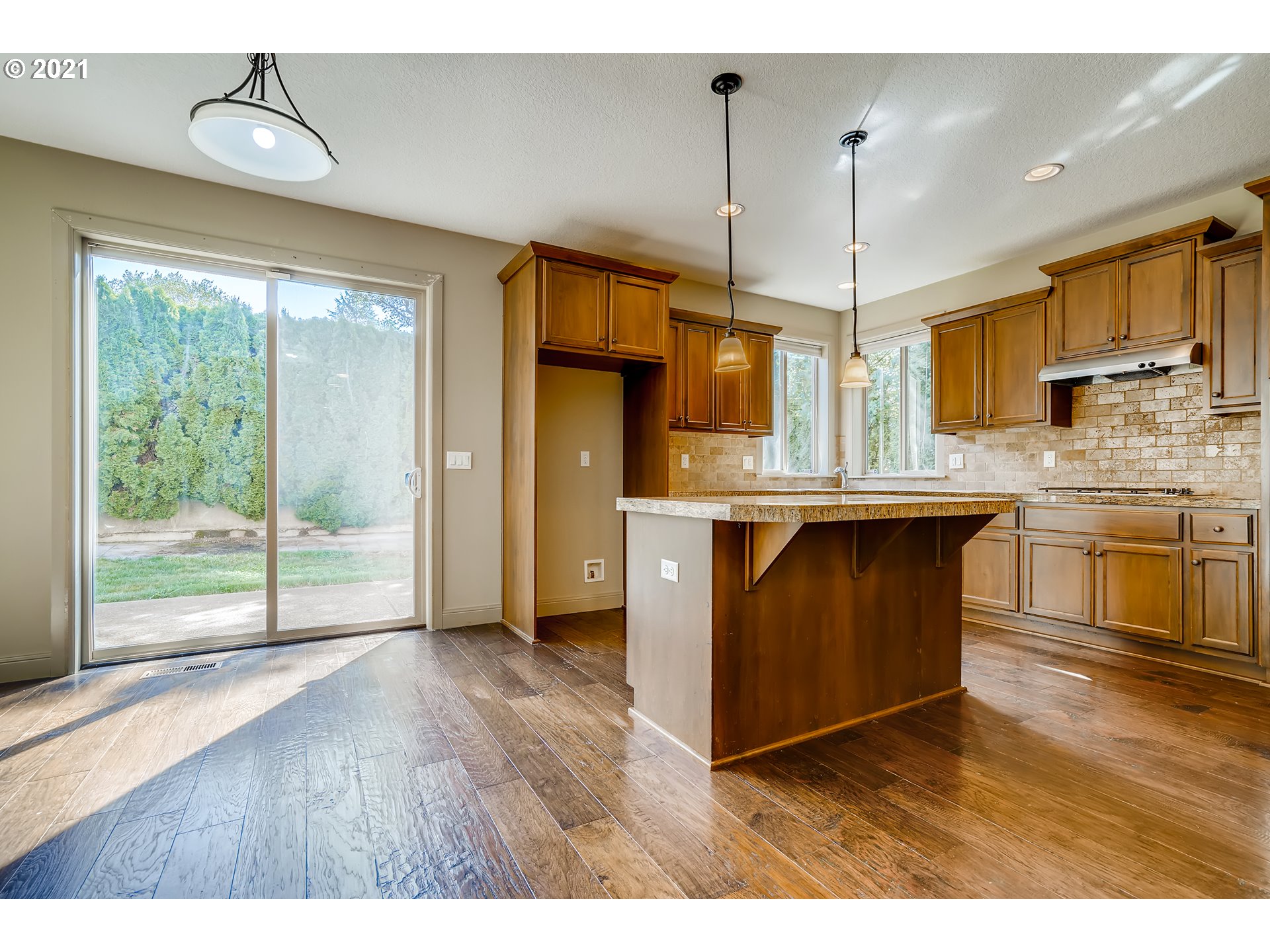 18378 Southwest Jeremy Street Beaverton, OR 97007 - Photo 14 of 31 a kitchen with kitchen island granite countertop a stove a sink and wooden floors