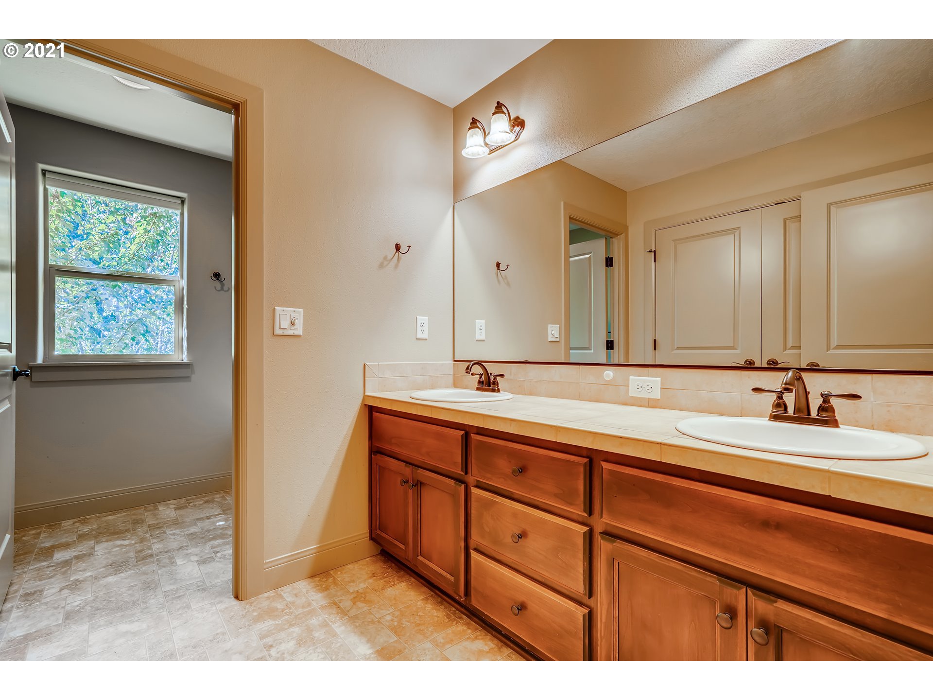 18378 Southwest Jeremy Street Beaverton, OR 97007 - Photo 27 of 31 a spacious bathroom with a double vanity sink and a mirror