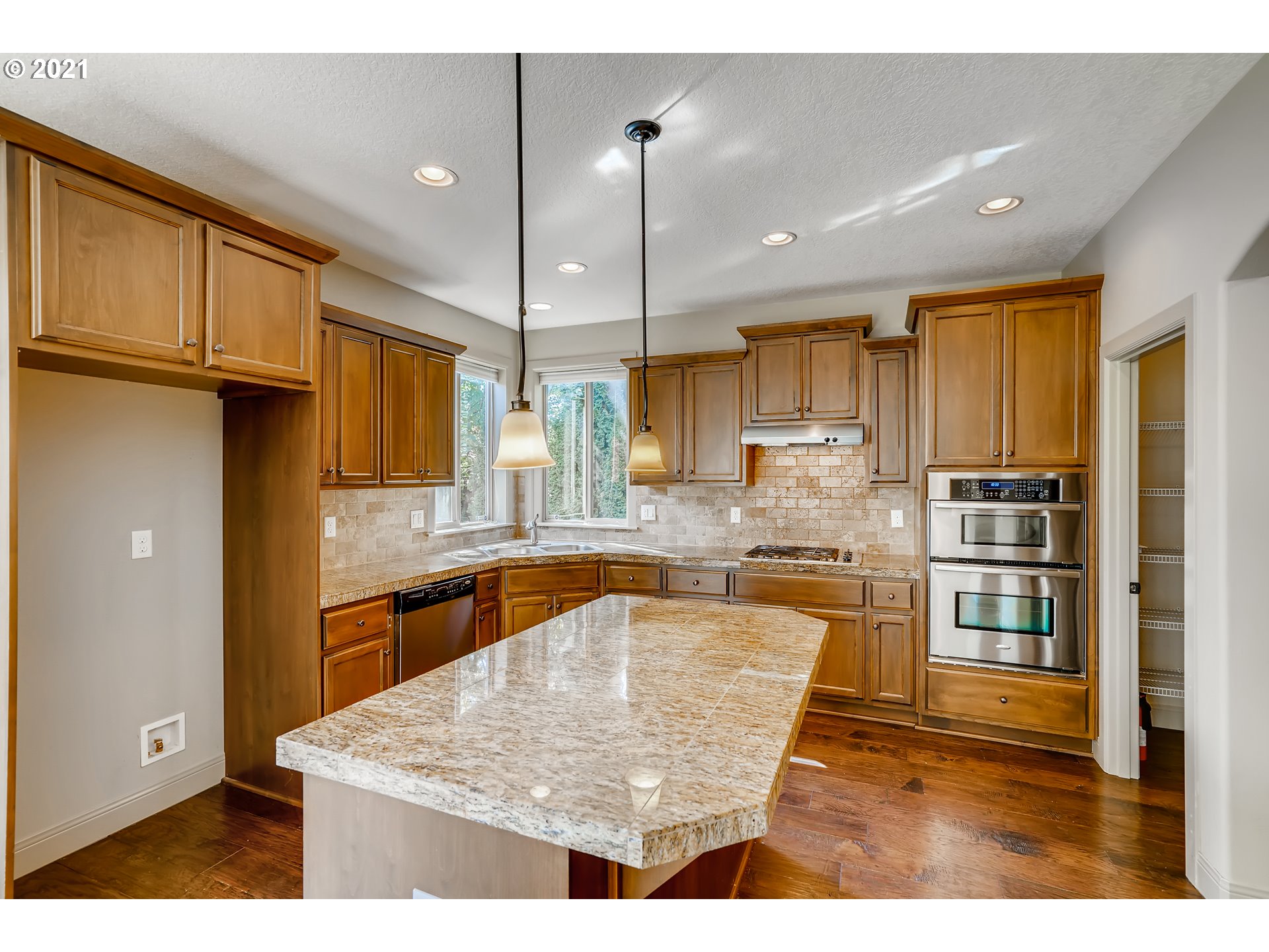 18378 Southwest Jeremy Street Beaverton, OR 97007 - Photo 10 of 31 a kitchen with stainless steel appliances granite countertop a refrigerator a sink a stove and a wooden cabinets