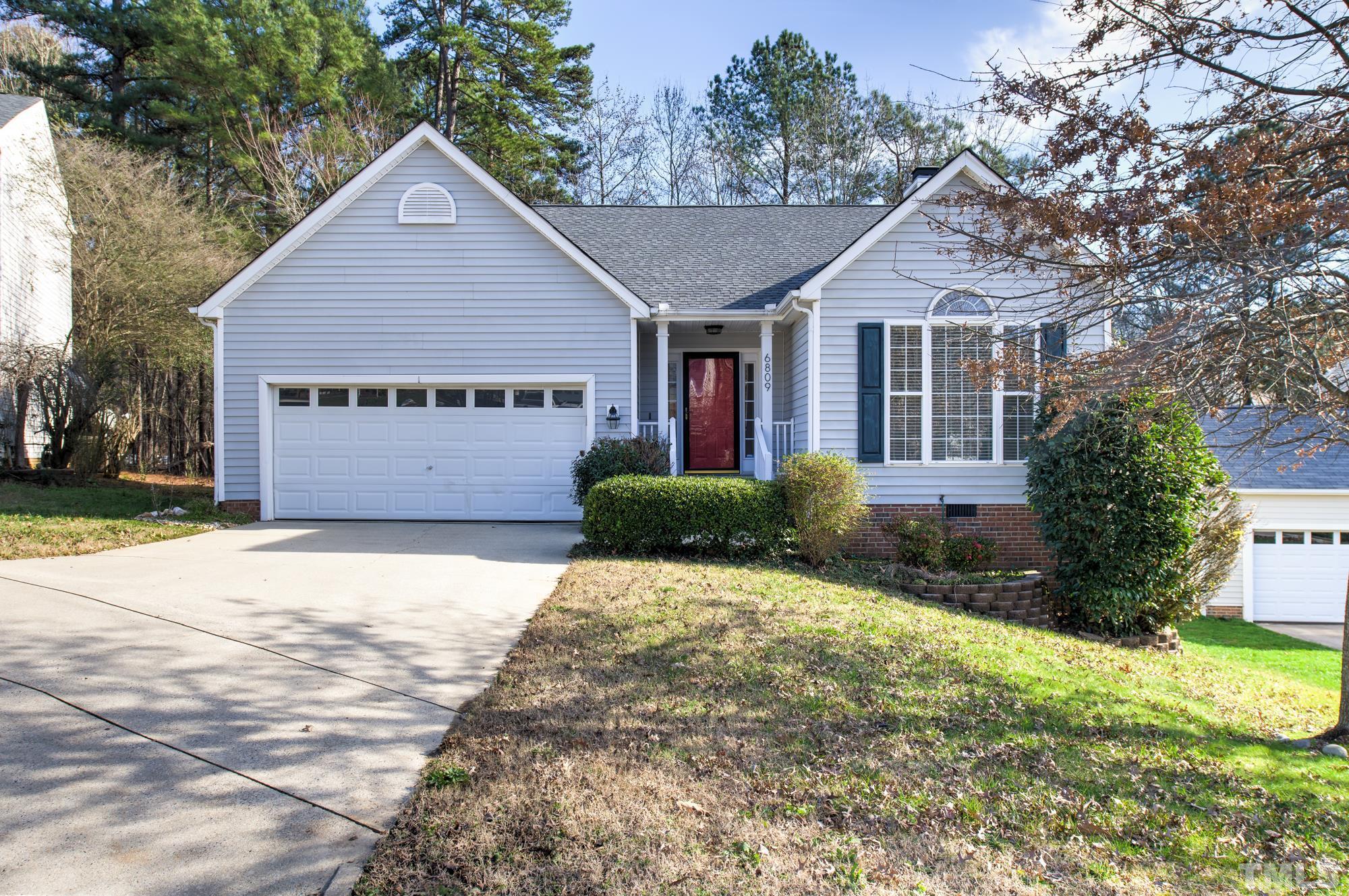 6809 Edwell Court Raleigh, NC 27617 - Photo 1 of 26 a front view of a house with a yard and garage