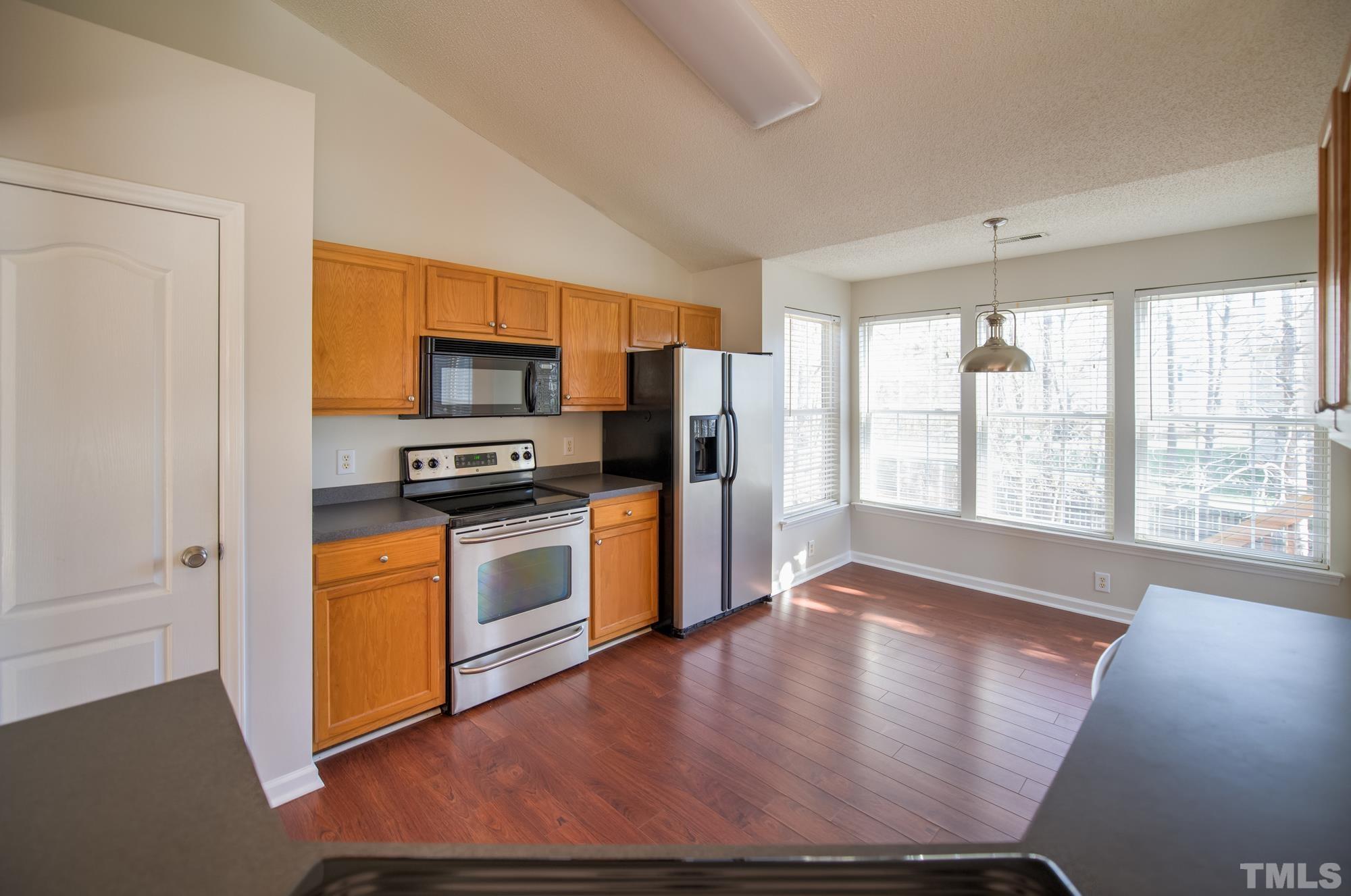 6809 Edwell Court Raleigh, NC 27617 - Photo 11 of 26 a kitchen with stainless steel appliances a refrigerator and a stove top oven
