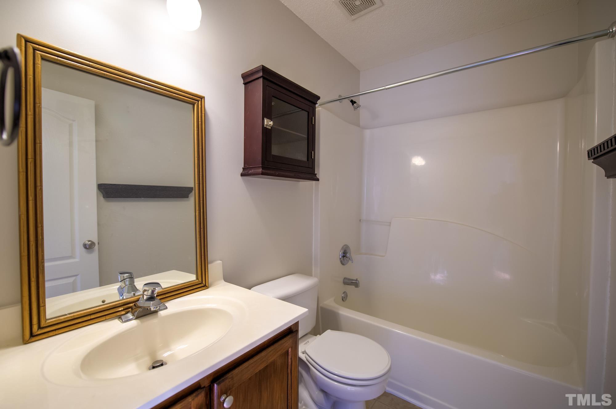 6809 Edwell Court Raleigh, NC 27617 - Photo 19 of 26 a bathroom with a sink a toilet and shower