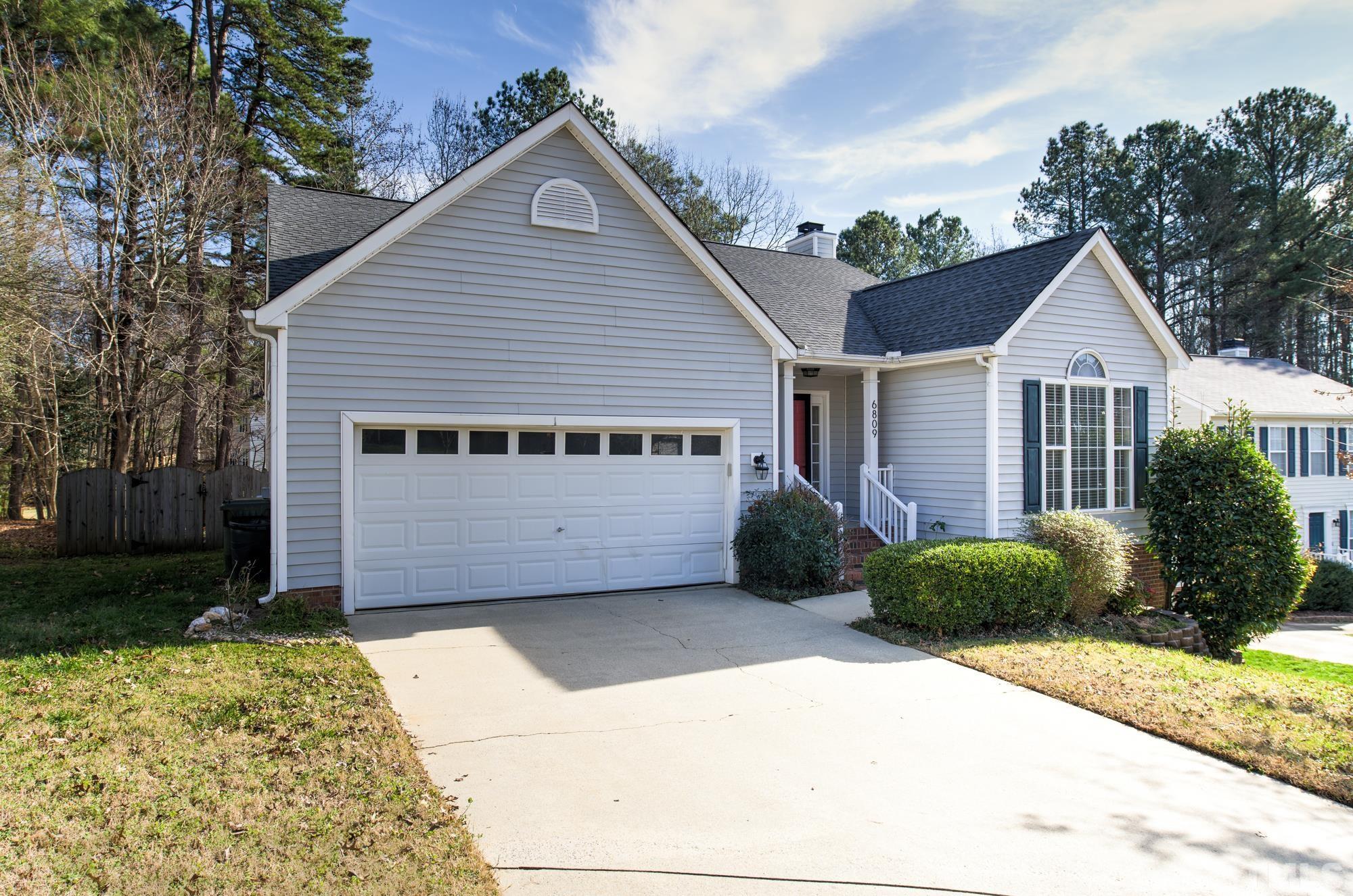 6809 Edwell Court Raleigh, NC 27617 - Photo 2 of 26 a view of a house with a small yard plants and a large tree