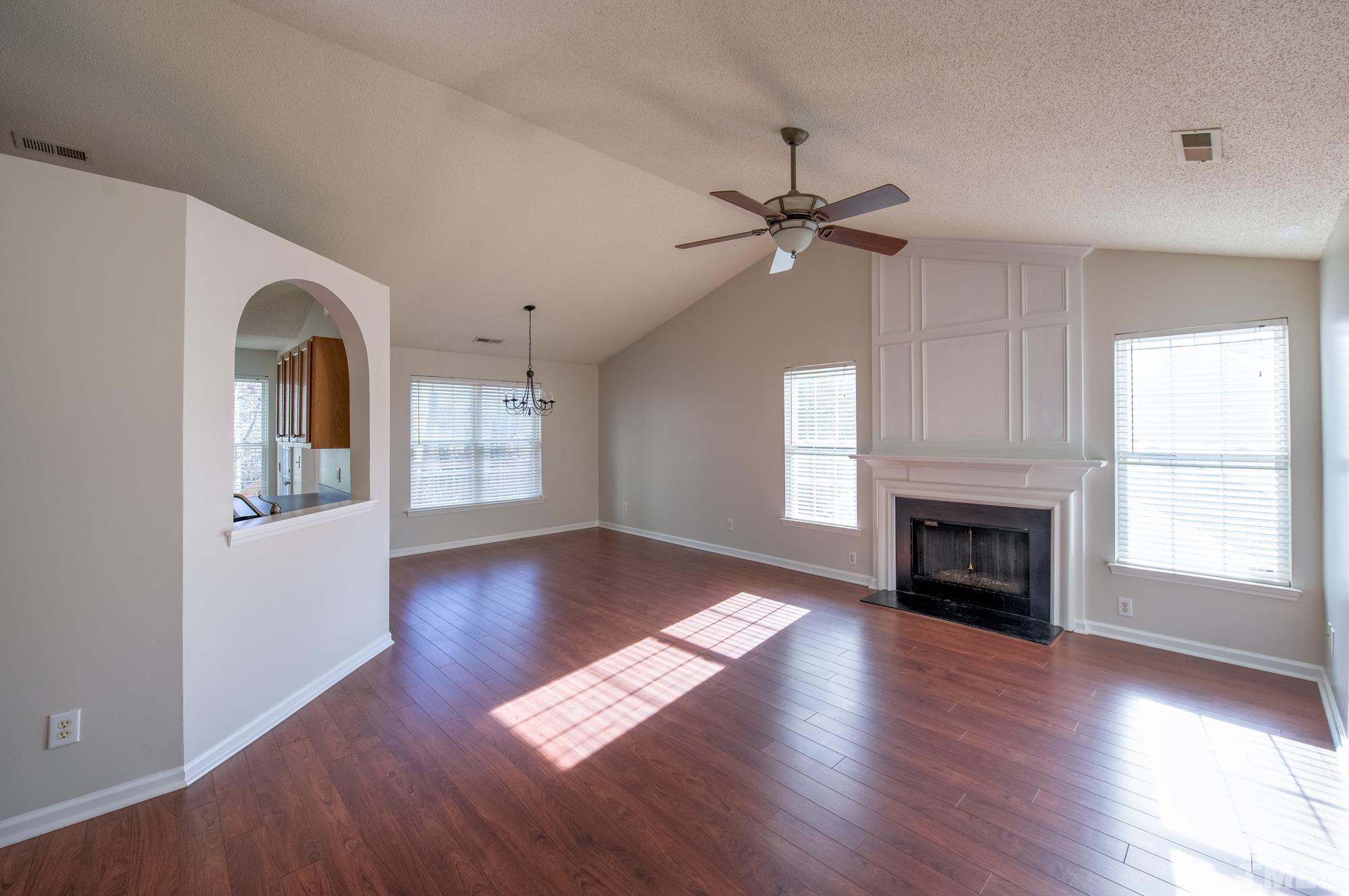 6809 Edwell Court Raleigh, NC 27617 - Photo 5 of 26 an empty room with wooden floor fireplace and windows