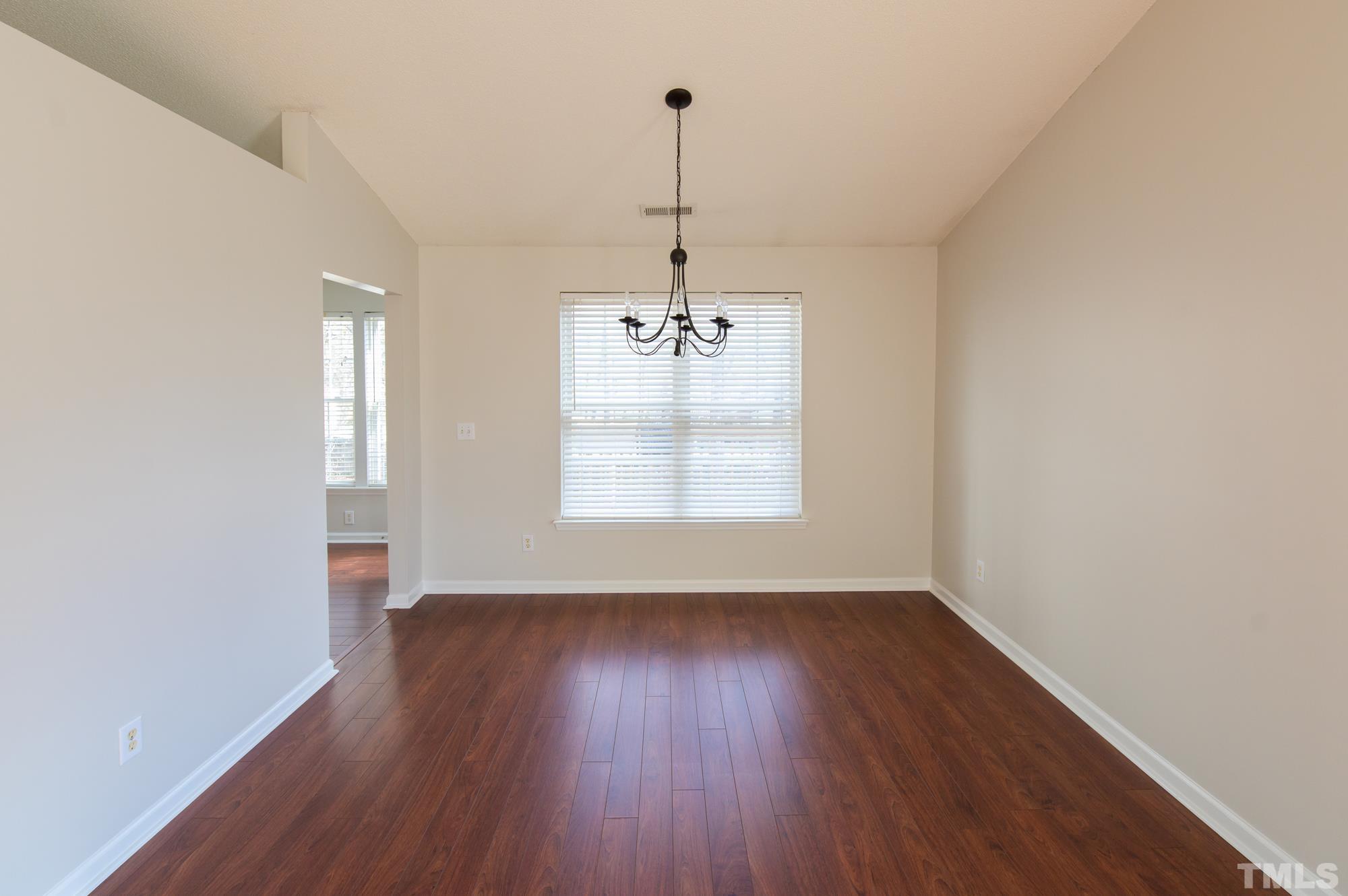 6809 Edwell Court Raleigh, NC 27617 - Photo 7 of 26 an empty room with wooden floor and windows