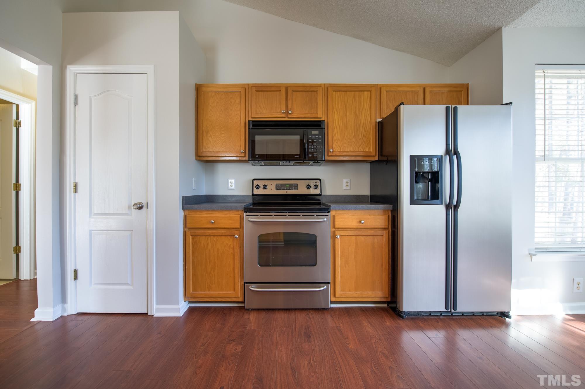 6809 Edwell Court Raleigh, NC 27617 - Photo 8 of 26 a kitchen with wooden floors and stainless steel appliances