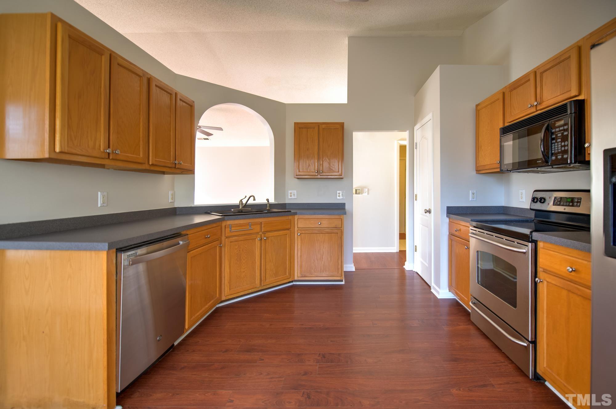 6809 Edwell Court Raleigh, NC 27617 - Photo 9 of 26 a kitchen with stainless steel appliances granite countertop a stove a sink and a microwave
