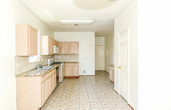 a kitchen with a sink a stove top oven and cabinets