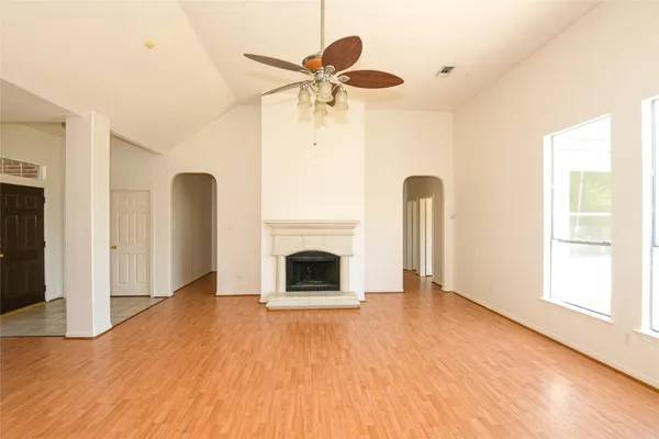 a view of empty room with fireplace and wooden floor