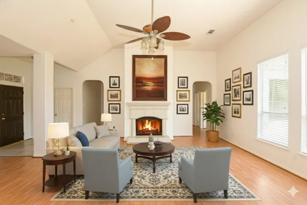 a living room with fireplace furniture and a large window
