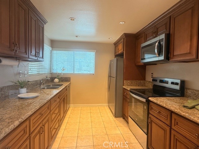 217 Tarocco Irvine, CA 92618 - Photo 4 of 13 a kitchen with stainless steel appliances granite countertop a sink and a stove