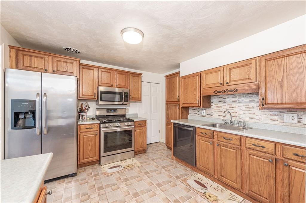 340 Spring Valley Road Pittsburgh, PA 15243 - Photo 11 of 44 a kitchen with stainless steel appliances granite countertop a stove a sink dishwasher a refrigerator and cabinets with wooden floor